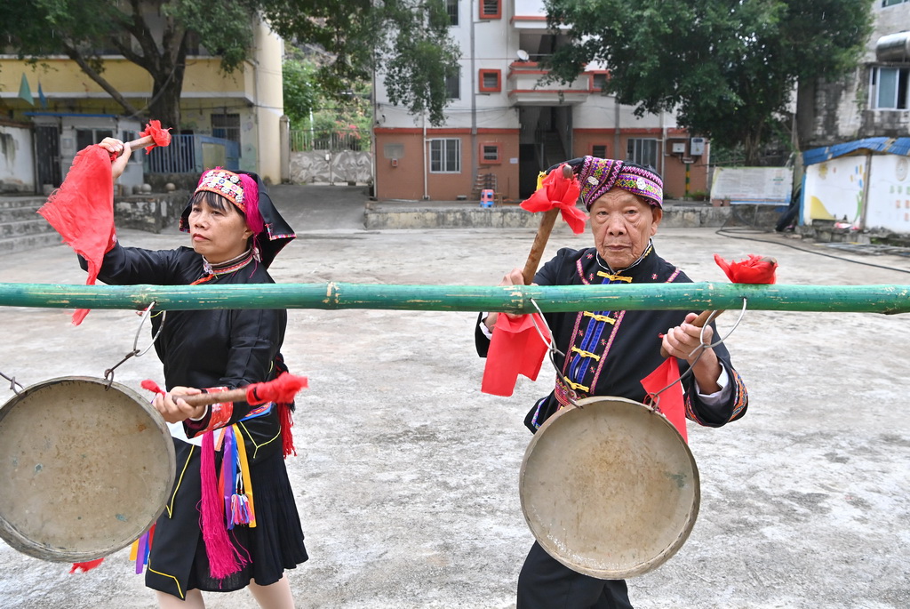 阮桂陸（右）和藝術團成員在田東縣作登瑤族鄉梅林村表演金鑼舞（10月28日攝）。